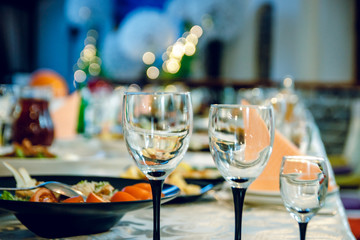 Three glasses on the festive table with food.