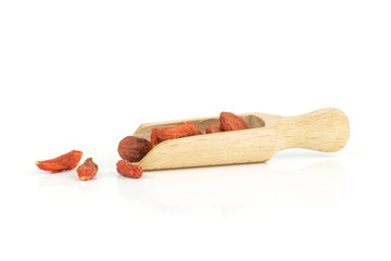 Lot of whole dried red goji berries with wooden scoop isolated on white background