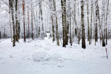 Fototapeta na wymiar Snowman in winter forest