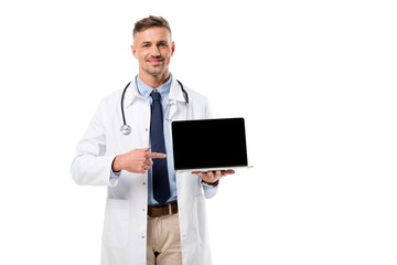 handsome doctor pointing at laptop with blank screen isolated on white