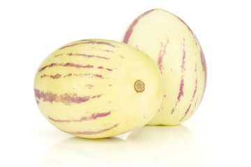 Group of two whole light yellow fresh striped pepino melon isolated on white background