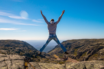 Happy Man jumping at mountains to clouds sky Lifestyle Travel emotional euphoria success concept...