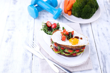 Healthy lunch for a beautiful body and fitness nutrition. Food and sports equipment on a white wooden background. Free space for text.