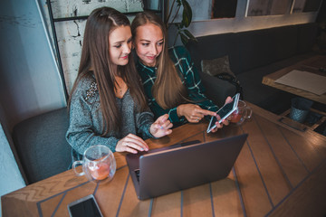 two modern women having meeting in cafe. working on laptop ant tablet