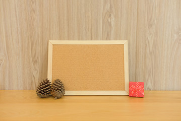 blank cork board with pine cone & gift box. christmas new year holiday