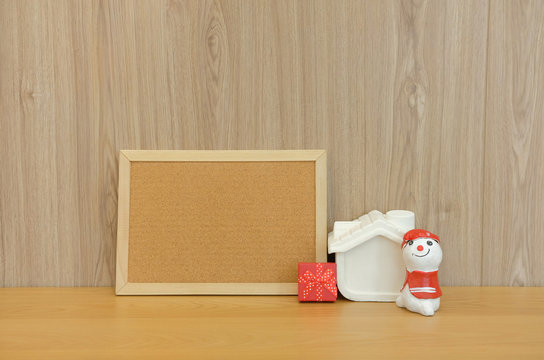 cork board snowman house miniature gift box on wooden desk table. christmas new year holiday - Powered by Adobe
