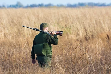 Schilderijen op glas The hunter in the hunting clothes and with rifle hunts © predrag1