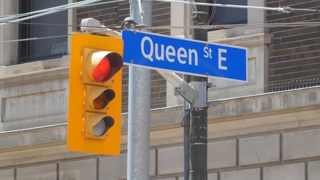 Queen Street street sign with stoplight. Toronto, Canada.