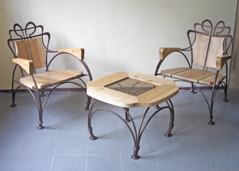 Fototapeta premium Two wooden chairs and a table with elements of forging. Home furniture made of wood. Interior design