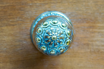 door handle on a wooden surface. metal handle on the door close-up. beautiful carved door handle