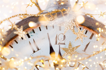 vintage alarm clock is showing midnight. It is twelve o'clock, christmas and bokeh, holiday happy new year festive concept on light bokeh background