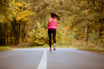 Female runner running during outdoor workout in the park.