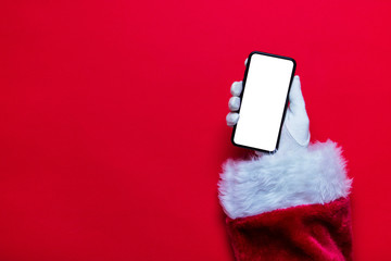 Santa Claus Christmas hand holding a phone against a red background