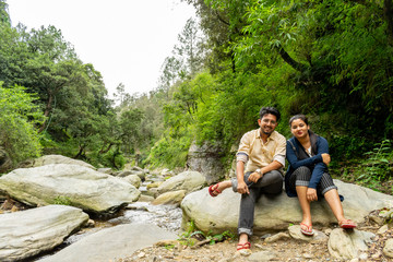 Naklejka na ściany i meble a stream, on the way to Bhalu Gaad waterfall, relaxing/ sitting on a rock after a long trek, Mukteshwar
