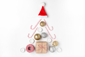 Christmas tree from golden and silver balls, gift, candles, lollipops, red hat santa claus Top view White Background Christmas New Year
