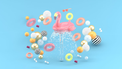 Flamingo rubber ring floating on a fountain surrounded by colorful rubber rings on a blue...