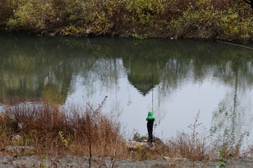 Fototapeta na wymiar fisherman on the river in autumn 
