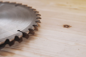 Circular saw on a wood background. Workshop. Manufacture of wooden products. Joiner's cutting tool