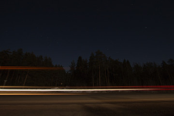 the night road is beautifully lit by the lights of passing cars