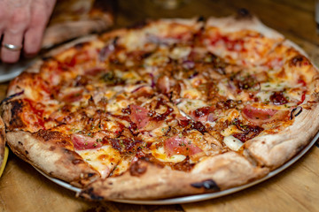 A delicious meat pizza sliced and read to be eaten, closeup