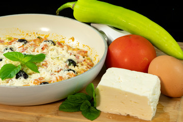Menemen with tomatoes, egg, green pepper, olives, halloumi cheese, basil, mint and thyme