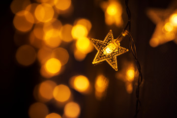 Garland in the form of stars. Blurry lights. Yellow light