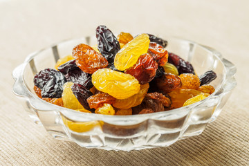Assortment of Raisins, yellow, blue, black, golden raisin  in glass bowl and wooden spoon on...