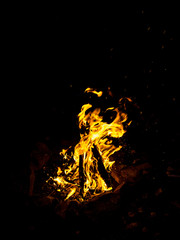 Fire close-up and red orange yellow color detail texture and abstract shape on black background.