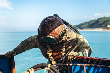 a diver in old equipment plunges into the sea