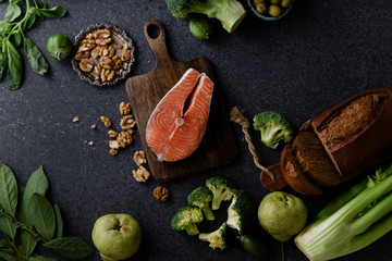 Fresh healthy food: vegetables, greens, fruits and raw salmon steak, walnuts and bread. Flatlay composition, top view. Healthy food ingredients concept.