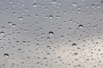 Close-up water drop. Water drops on glass surface as background. Drops of rain on glass. Sky background. Thailand.