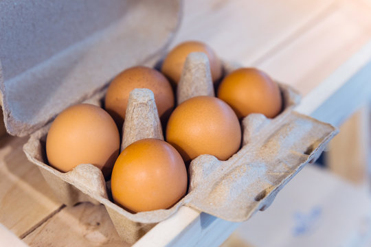 Brown chicken eggs in a brown carton box contain six eggs.