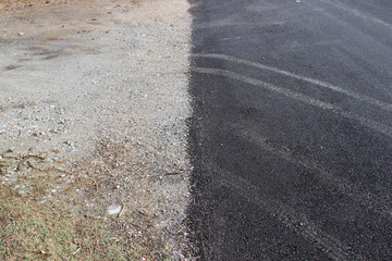 Paved and unpaved road border detail with tyre tire tracks