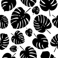 Black and white tropical leaves seamless pattern. Silhouettes of monstera leaf on white background. Vector illustration. © helenfox