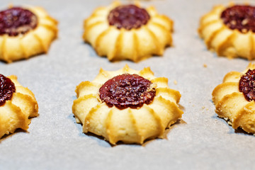 Homemade shortbread cookies with jam on cooking paper. Background