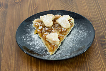 Apple pie served in glass service plate with isolated black background