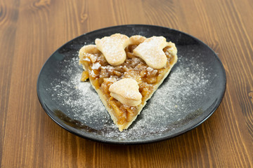 Apple pie served in glass service plate with isolated black background