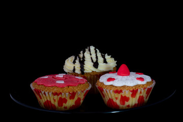 Fresh baked delicious different cupcakes served together with isolated black background