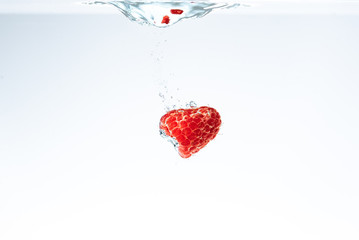 Raspberry falls deeply under water with a splash.