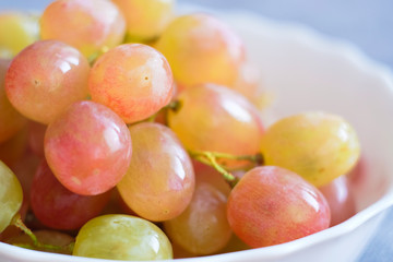 Grapes in a porcelain plate. Ripe pink Muscat grapes.