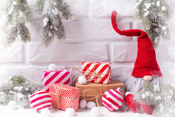 Elf, wrapped christmas presents, balls,  fur tree branches on white textured  background.
