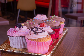 Fresh baked delicious different cupcakes served together with wood background