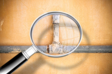 Check the old water pipes - Concept image seen through a magnifying glass