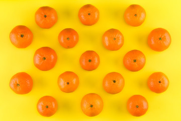 Fruit pattern of mandarin isolated on yellow background. Tangerine. Flat lay, top view.