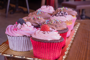 Fresh baked delicious different cupcakes served together with wood background