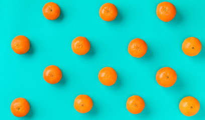 Fruit pattern of fresh mandarin on blue background. Flat lay, top view. Pop art design, creative summer concept. Citrus in minimal style.