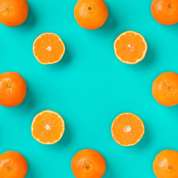 Fruit pattern of fresh mandarin slices on blue background. Flat lay, top view. Pop art design, creative summer concept. Half of citrus in minimal style. Tangerine.