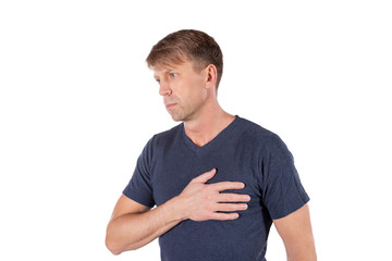 Obraz premium Man holding his chest with hands, having heart attack or painful cramps, pressing on chest with painful expression on white background. Severe heartache
