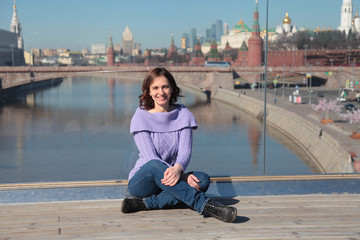 Fototapeta na wymiar Young woman on a glass bridge on the background of the Moscow Kremlin.