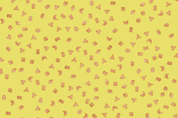 Small cookies, crackers of various shapes on a yellow background